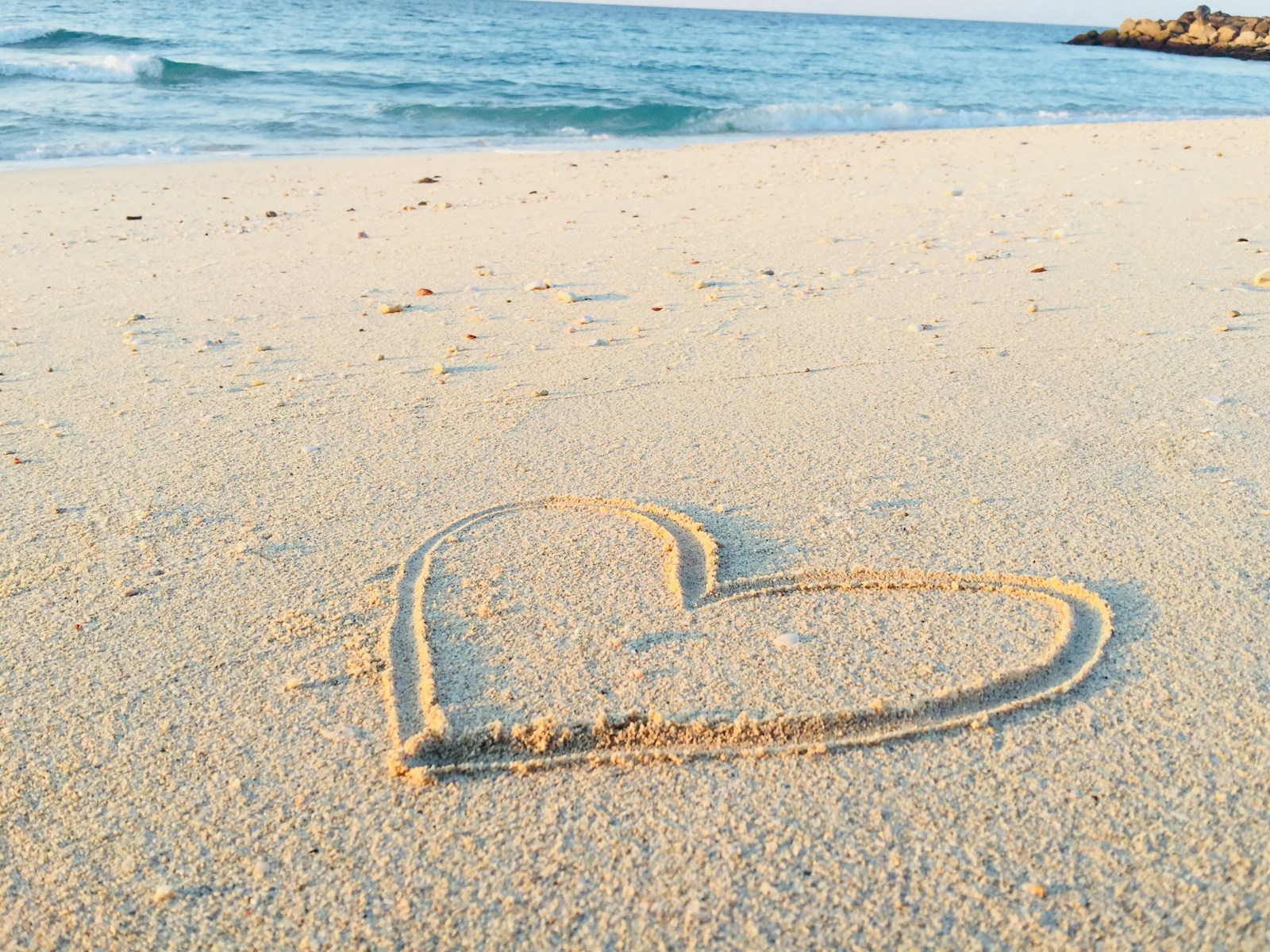 Photo by Khadeeja Yasser heart drawn on sand during daytime